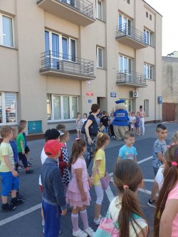 Dzieci witające się z Pyrkiem przed budynkiem komendy