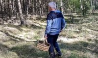 Mężczyzna z koszykiem wiklinowym w lesie