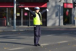 policjant na skrzyżowaniu pokazujący światło zielone