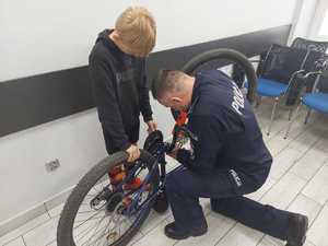Na zdjęciu widzimy funkcjonariusza policji znakującego rower w ramach E-usługi Wiberoo - Wielkopolski Bezpieczny Rower.