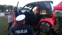 policjant stojący przy symulatorze dachowania