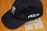 leżąca na stoliku czapka policjanta, pod którą leżą dwa blankiety prawa jazdy