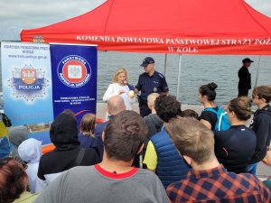 Na zdjęciu widzimy działania profilaktyczno-edukacyjne prowadzone przez policjantów, strażaków, ratowników WOPR, przedstawicieli PCK oraz inspekcji sanitarnej nad Jeziorem Brdowskim.