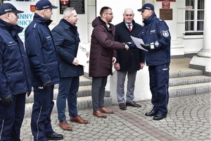 Na obrazku widzimy funkcjonariuszy policji wspólnie z władzami miasta Koła w trakcie przekazania nieoznakowanego radiowozu maki Hyundai. Przekazanie odbywa się przed budynkiem Ratusza Miejskiego w Kole.