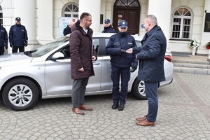 Na obrazku widzimy funkcjonariuszy policji wspólnie z władzami miasta Koła w trakcie przekazania nieoznakowanego radiowozu maki Hyundai. Przekazanie odbywa się przed budynkiem Ratusza Miejskiego w Kole.