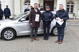 Na obrazku widzimy funkcjonariuszy policji wspólnie z władzami miasta Koła w trakcie przekazania nieoznakowanego radiowozu maki Hyundai. Przekazanie odbywa się przed budynkiem Ratusza Miejskiego w Kole.
