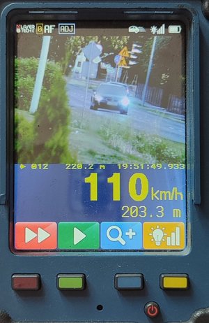 Na obrazku widzimy obraz z miernika prędkości gdzie widoczny jest pojazd koloru ciemnego oraz pomiar jego prędkości.